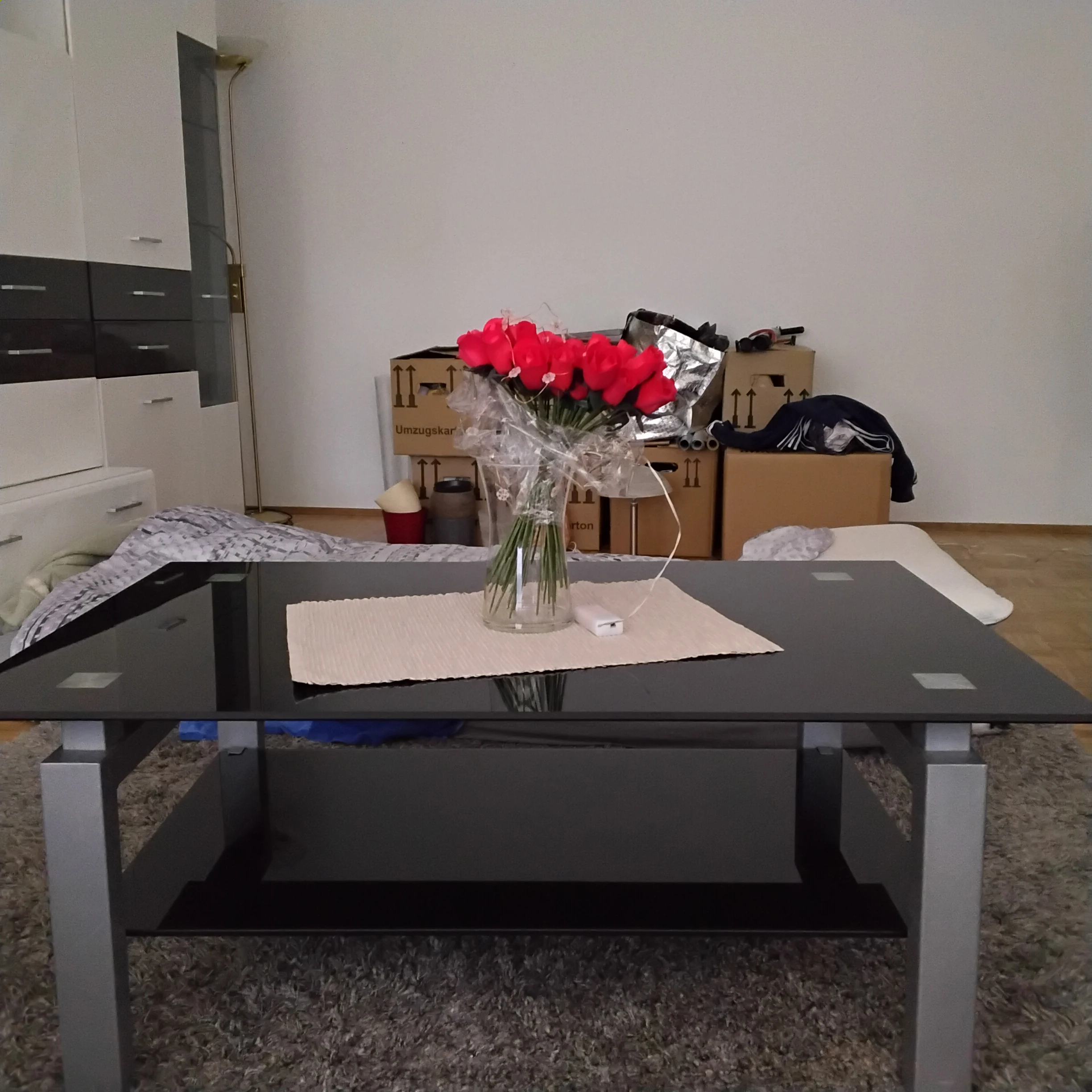Tisch mit glänzender schwarz/silbernen Glasplatte