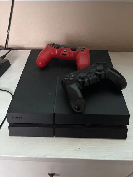 Wie auf dem Bild zu sehen, ist die PlayStation vier mit zwei Controllern in einem guten Zustand